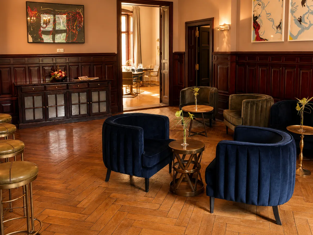 Lounge im Schlosshotel Reichenow mit Sesseln, Holzvertäfelung und Kunst
