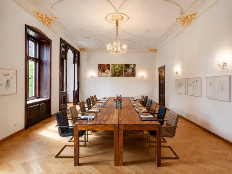 Tagungsraum im Schloss Reichenow mit großem Konferenztisch und Kronleuchter